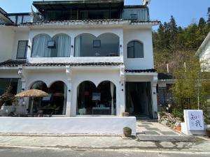 TaipingZhiwo B&B Fanjingshan East Branc的大型白色房屋,设有大窗户