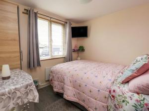 a bedroom with a bed with a pink blanket at Sandbay in Bridlington