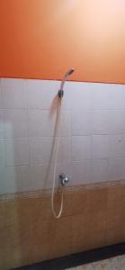 una ducha con una manguera fijada a una pared en Hotel O Classic Guesthouse, en Balikpapan