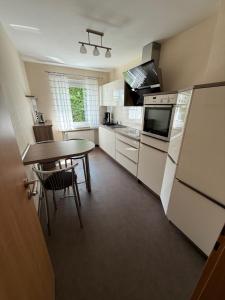 a kitchen with a table and a refrigerator and a table at CAL Apartments in Duisburg