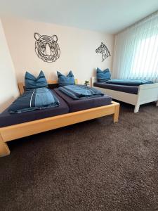 two beds in a bedroom with blue pillows at CAL Apartments in Duisburg