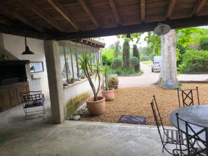 Gîte en Provence في كافايو: فناء مع طاولة وكراسي وزرع الفخار
