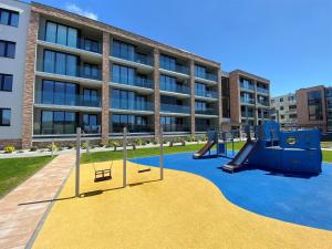 a playground in front of an apartment building at Kaya Apartament De Luxe 2 z basenem in Kołobrzeg