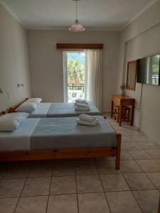 Un dormitorio con dos camas y una ventana. en Avra Rooms, en Kerion