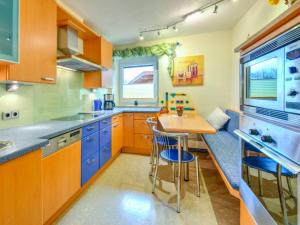 a kitchen with blue cabinets and a small table at Innradweg in Angath