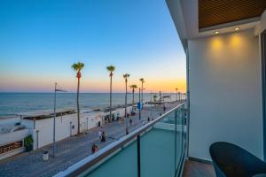 ein Blick auf den Strand vom Balkon eines Gebäudes in der Unterkunft THE OCEAN - Luxury Apartment at the Harbor in Paphos