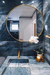 ein Badezimmer mit großem Spiegel und Waschbecken in der Unterkunft THE OCEAN - Luxury Apartment at the Harbor in Paphos