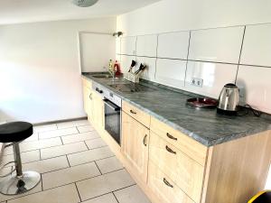 a kitchen with wooden cabinets and a counter top at Pension Jasmin A in Chemnitz