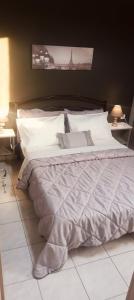 a bed with white sheets and pillows in a bedroom at Marinas Apartments Alexandroupolis in Alexandroupoli
