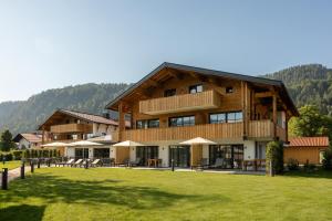 una gran casa de madera con césped delante en Das Denisl, en Reit im Winkl