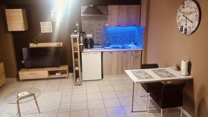 a kitchen with a table and a television and a kitchen with a counter at Marinas Apartments Alexandroupolis in Alexandroupoli