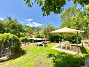 a garden with a tent and a table and chairs at Villetta di Sara tra Arezzo, Siena, Firenze e il Chianti in San Giovanni Valdarno
