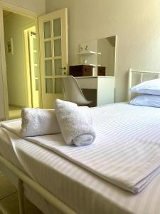 a white bed with towels on top of it at Diamond Maisonette in Kavála