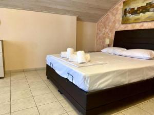 a bedroom with a large bed with towels on it at Diamond Maisonette in Kavála