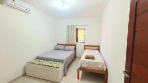 une petite chambre avec un lit et une chaise dans l'établissement Casa ROSA in Antunes Maragogi, à Maragogi