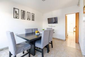 Un comedor con una mesa y sillas negras. en Alojamiento temporal La Josefina, en Tandil