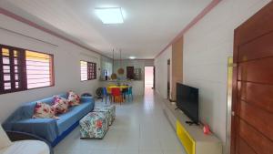 un salon avec un canapé bleu et une télévision dans l'établissement Casa ROSA in Antunes Maragogi, à Maragogi