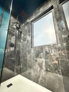 a bathroom with a shower with a window at Havana Hideaway Downtown Saugatuck Walk everywhere in Saugatuck