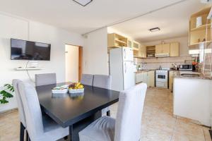 a kitchen with a dining room table and chairs at Casa familiar para 7 con Parrilla, Desayuno incluido y A 5 min Piedra Movediza in Tandil