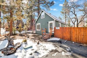 a green house in the snow with a fence at Cute and Cozy Cottage #2522 in Sugarloaf