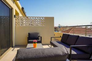 a balcony with a couch and a chair on a roof at Afali City Center apartments in Zakynthos Town
