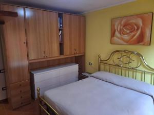 a bedroom with a white bed and wooden cabinets at Casa vacanze Malinini in Savogna
