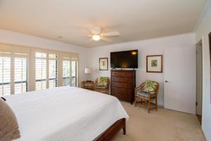 Un dormitorio con una cama y un televisor de pantalla plana. en 145 Ocean Point Dr, en Fripp Island