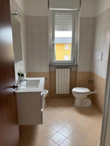 a bathroom with a toilet and a sink and a window at Appartamento vicino a Como e Milano in Mozzate