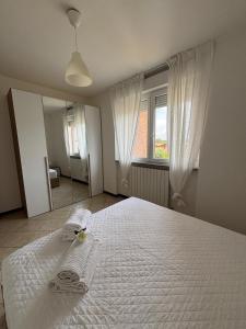 a bedroom with a white bed with two towels on it at Appartamento vicino a Como e Milano in Mozzate