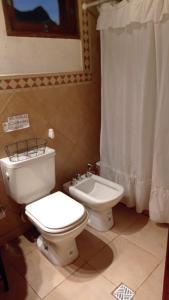 a bathroom with a toilet and a bidet at El Quitapenas Tilcara in Tilcara