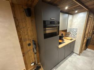 a kitchen with a stove top oven next to a counter at Studio pied des pistes Les Gets - 4 pers rénové in Les Gets +2 photos