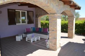 a patio with a couch under a brick arch at B&B A Casa di Lilla in Giulianova