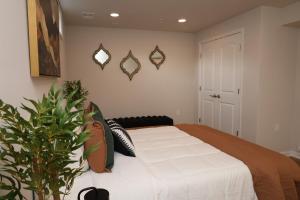 a bedroom with a bed and a potted plant at Ultra Luxe 2B Basement Apartment in Lanham