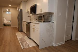 a kitchen with white cabinets and a microwave at Ultra Luxe 2B Basement Apartment in Lanham