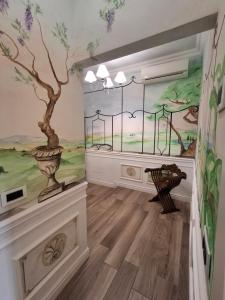 una stanza con un murale di un albero sul muro di E R Suite a Cremona