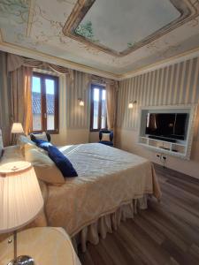 una camera da letto con un letto grande e una TV a schermo piatto di E R Suite a Cremona