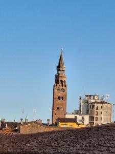 Un palazzo alto con una torre dell'orologio in una città di E R Suite a Cremona
