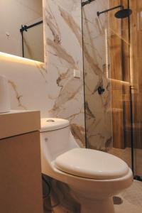 a bathroom with a toilet and a glass shower at Cozy big house in Paracas +10 photos