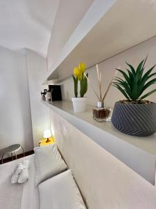 een kamer met een witte bank en planten op een plank bij San Pietro Charme in Rome +15 foto's