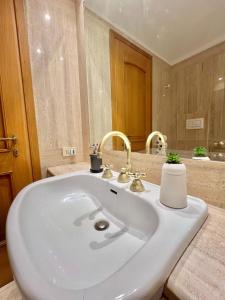 een badkamer met een witte wastafel en een spiegel bij San Pietro Charme in Rome