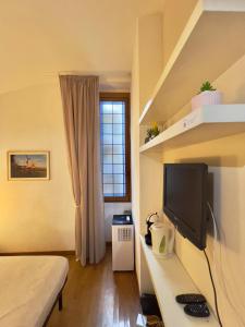 een slaapkamer met een bed en een bureau met een televisie bij San Pietro Charme in Rome