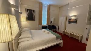 Rúm í herbergi á Kellys Hotel