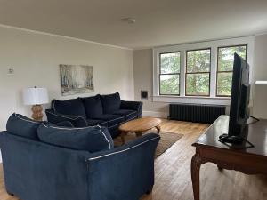 a living room with two blue couches and a tv at Sawyer Cove Cottage in Jonesport