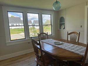 a dining room with a table and chairs and windows at Sawyer Cove Cottage in Jonesport +12 photos