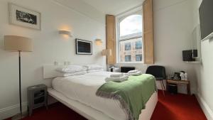 Rúm í herbergi á Kellys Hotel