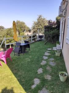 einen Hinterhof mit einem Tisch und Stühlen sowie einem Tisch und Stühlen in der Unterkunft Ground floor of villa in Brando + 2 Fotos