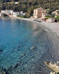 einen Strand mit blauem Wasser sowie Gebäude und Häuser in der Unterkunft Ground floor of villa in Brando