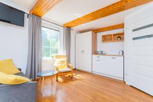 a living room with a couch and a kitchen at Malinowka in Jantar