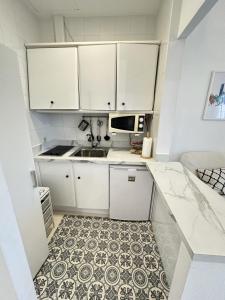 mała kuchnia ze zlewem i kuchenką mikrofalową w obiekcie Encantador apartamento en el centro de Sevilla w Sewilli
