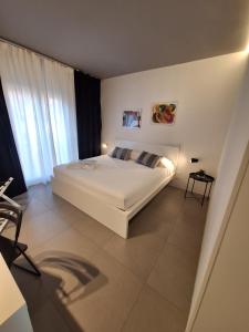 a bedroom with a white bed and a large window at Perla delle Egadi in Marsala
